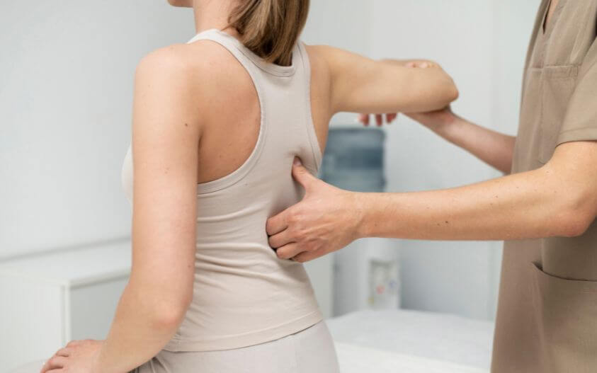 Chiropractor providing back pain treatment during a spinal evaluation