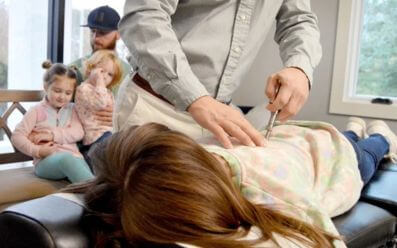 Chiropractor applying a lumbar adjustment to reduce sciatica pain
