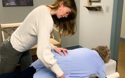 Chiropractor performing hip adjustment to ease sciatic nerve pressure
