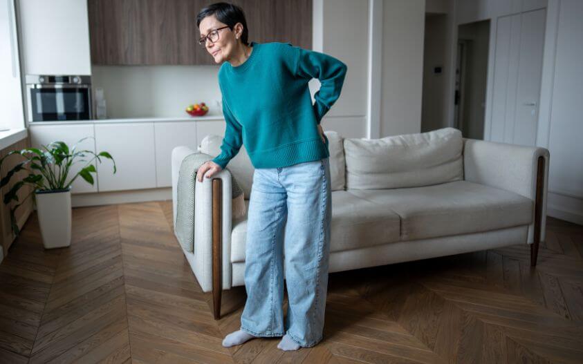 Woman holding lower back due to sciatica nerve pain