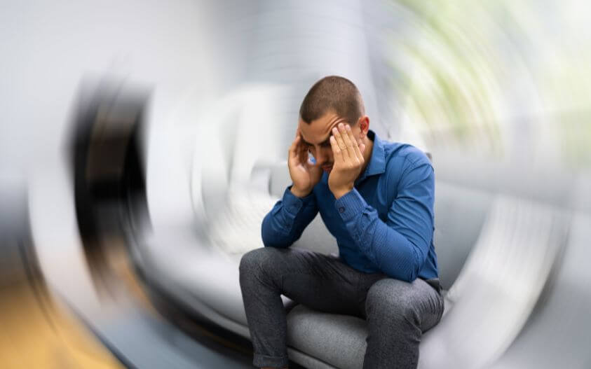 Man holding his head while experiencing vertigo symptoms